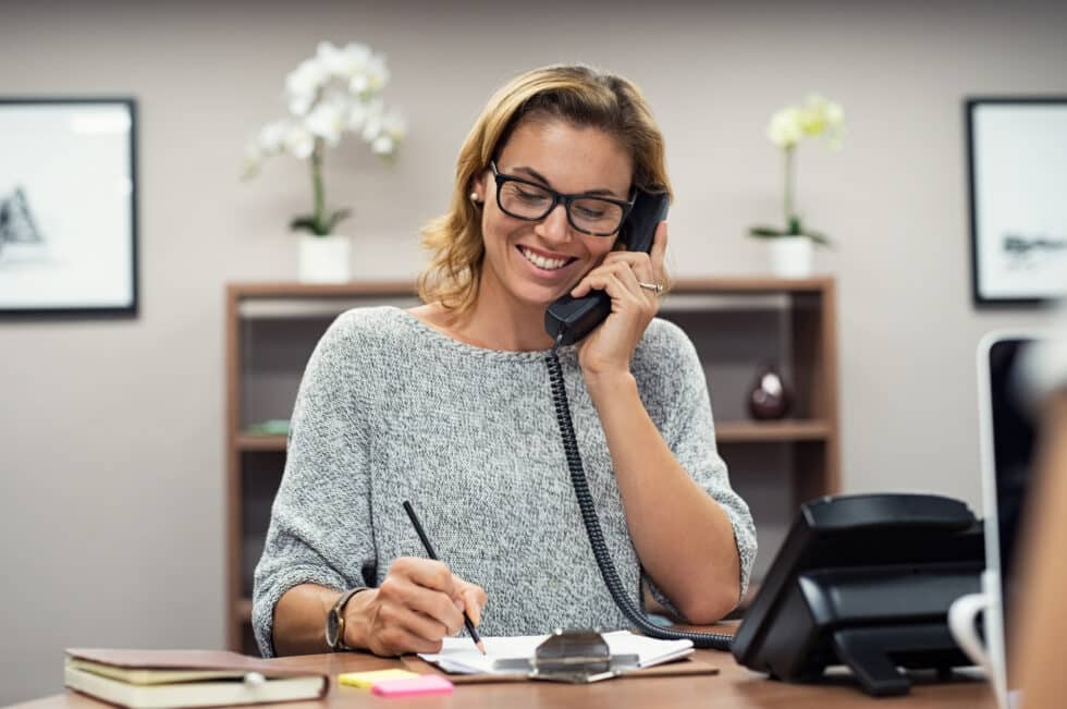 Happy male entrepreneur with headset using laptop in the office.